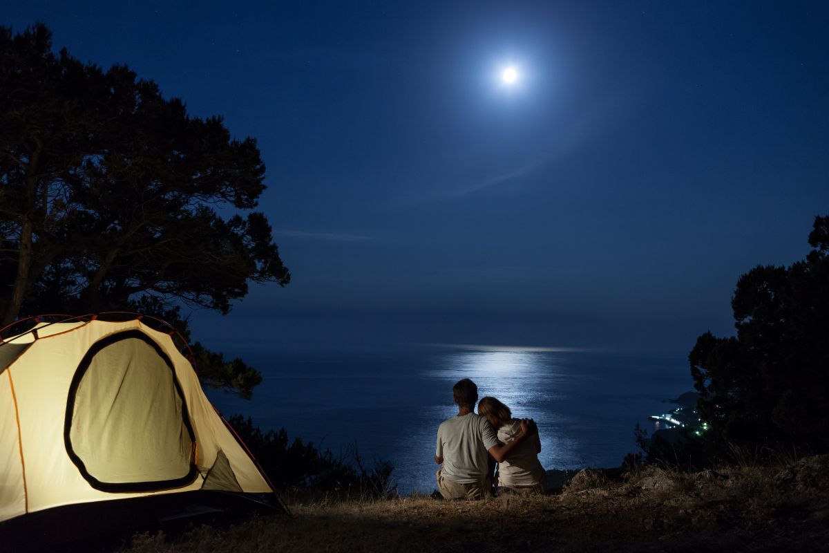 a couple stargzing while on a romantic camping trip